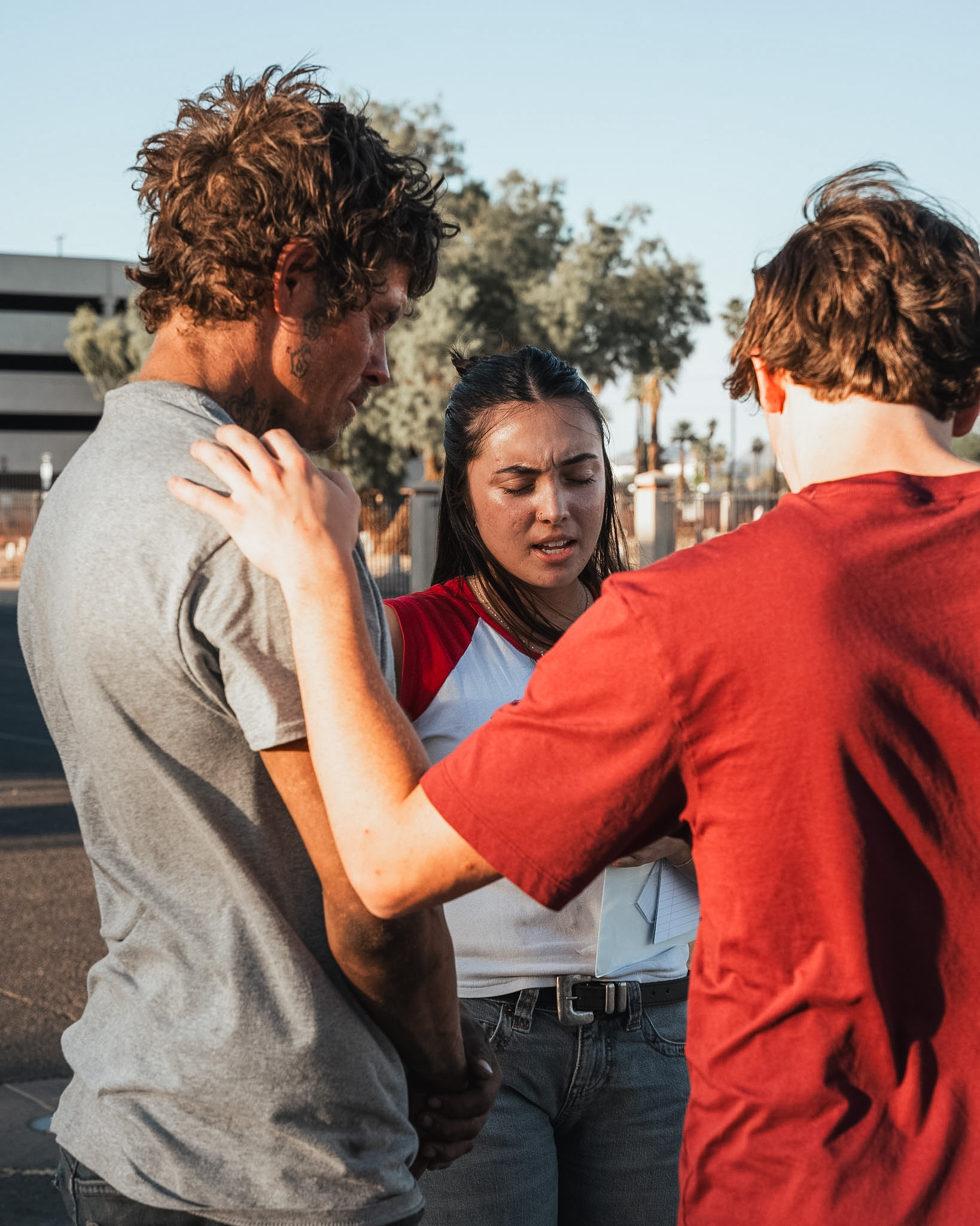 Volunteers praying together with someone on the street