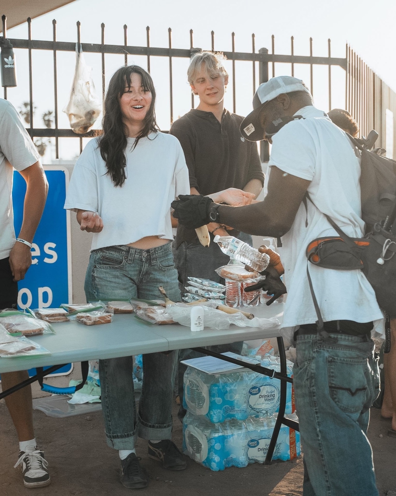 Volunteers serving food and water at an outreach table